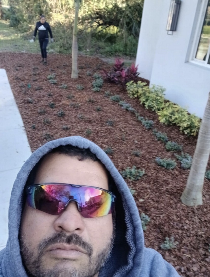 Crew member at a freshly mulched and planted garden bed